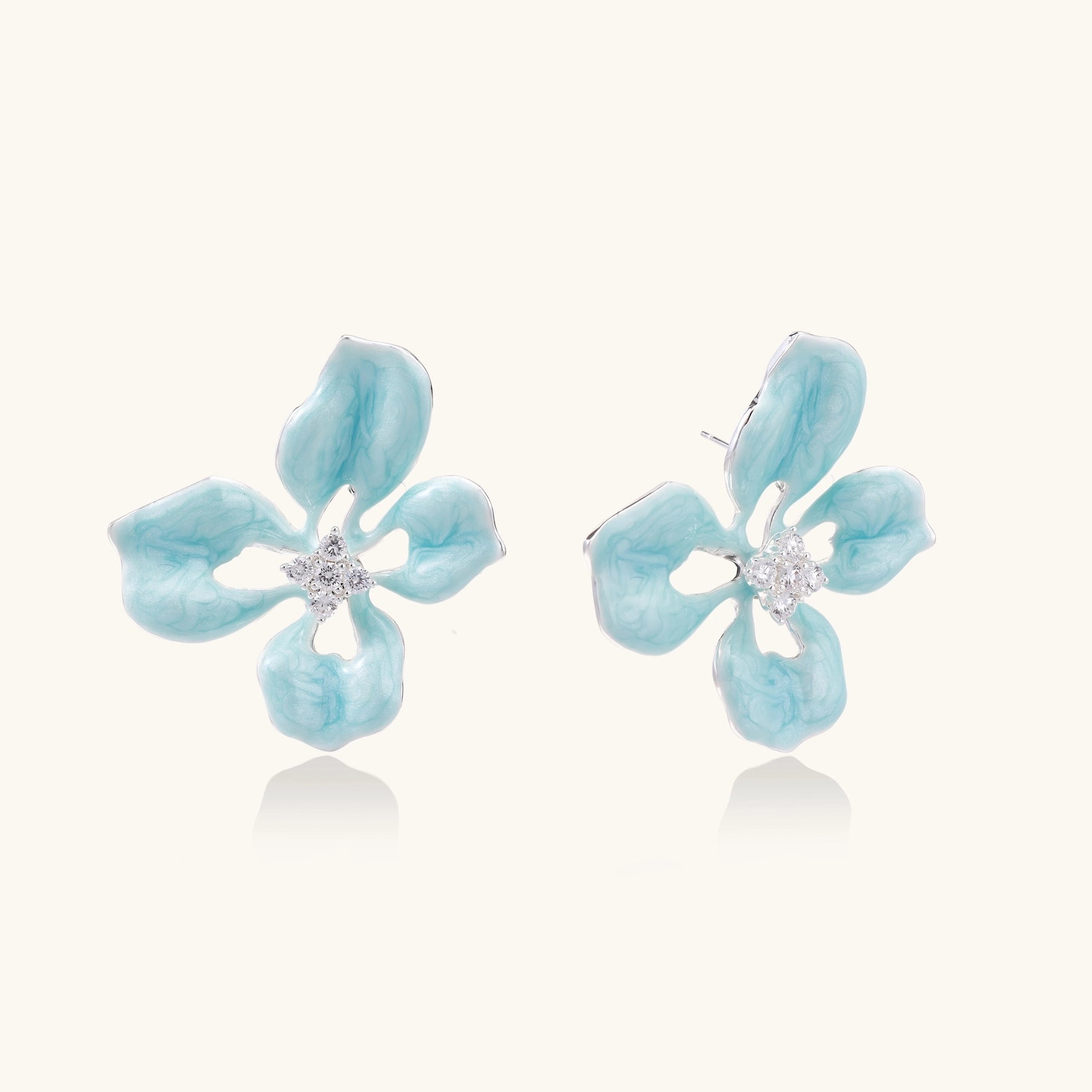 Turquoise blue enamel flower earrings with crystal centers and gold-plated brass posts on white background.