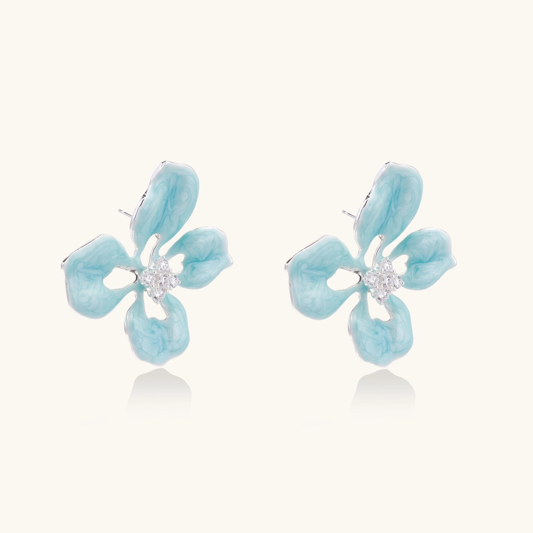 Turquoise blue enamel flower earrings with crystal centers and gold-plated brass posts on white background.